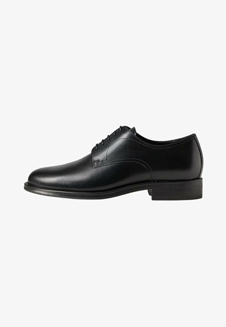 Chaussure habillée Oxford pour hommes en cuir noir avec laçage fermé, petit talon et finition lisse et polie, présentée de profil sur fond blanc.