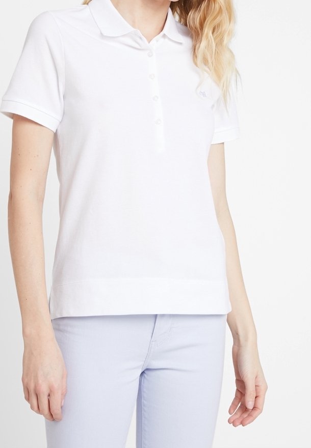 Polo shirt blanc en coton, avec un col classique, des manches courtes et une patte de boutonnage à trois boutons. Coupe slim avec un ourlet droit.