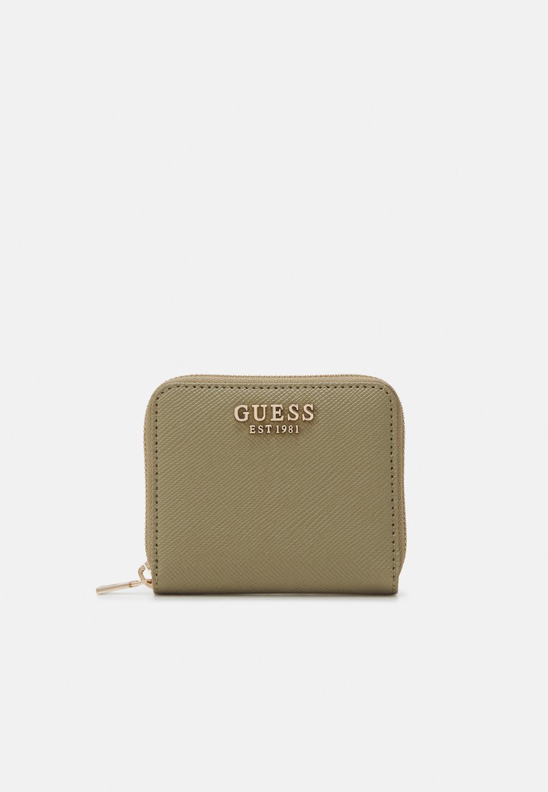 Grønn teksturert lommebok med gullfarget "GUESS EST1981"-logo, glidelås og kompakt rektangulær form.