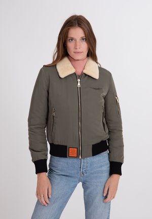 Bomberjack in olijfgroen met een crèmekleurige nepbontkraag, een ritssluiting aan de voorkant, ribgebreide manchetten en een oranje label op de taille. Glad textuur.
