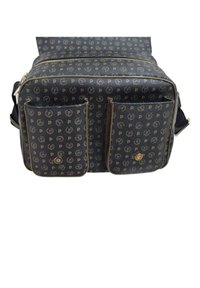 Borsa di tessuto nero caratterizzata da un motivo ripetitivo del logo, due tasche laterali, accessori in tonalità oro e chiusura con zip sulla parte superiore. Design compatto e rettangolare.