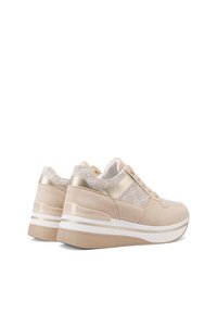 Sneakers platform beige con un sottile motivo a pizzo, materiale in morbida pelle scamosciata, dettagli dorati e una suola striped bianca e beige.