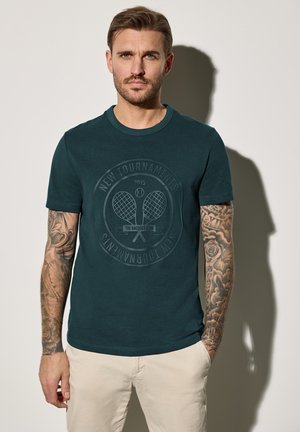 Teal katoenen t-shirt met een ronde hals, korte mouwen en een gestructureerd gedrukt logo met tennisrackets en tekst, met een gladde afwerking.