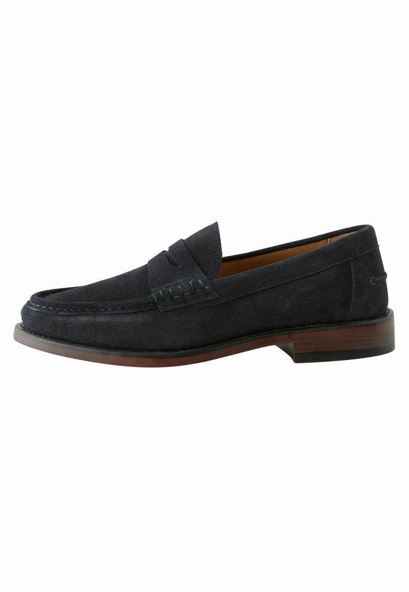 Mocasines azul marino de ante con un diseño de mocasín, que presentan costuras decorativas, una puntera redondeada y un bajo tacón de madera apilada.