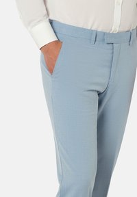 Pantalon bleu clair avec un devant plat, des poches latérales et un tissu texturé. Présente une taille standard et une coupe ajustée.
