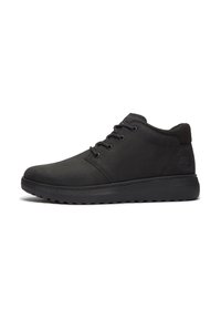 Zapatos de cuero negros con un perfil bajo, punta redondeada, diseño de cordones y suela de goma, con un upper texturizado y un branding sutil.