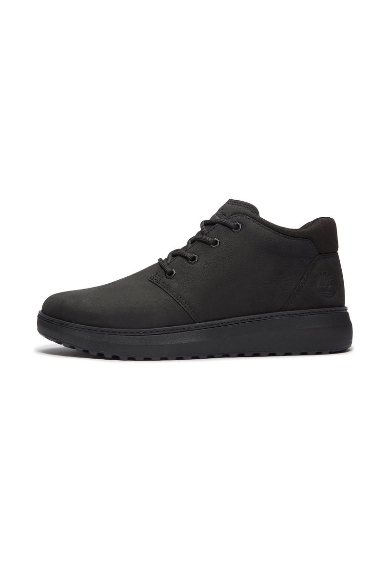 Zapatos de cuero negros con un perfil bajo, punta redondeada, diseño de cordones y suela de goma, con un upper texturizado y un branding sutil.