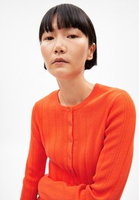 Helles, orange, geripptes Cardigan mit rundem Ausschnitt, das eine Knopfleiste vorne und lange Ärmel hat. Glatte Textur und taillierte Form.