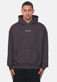 Dunkelgrauer Kapuzenpullover aus weichem Material. Verfügt über eine Kängurutasche und weißen, auf der Brust zentrierten Text "DROPSIZE".