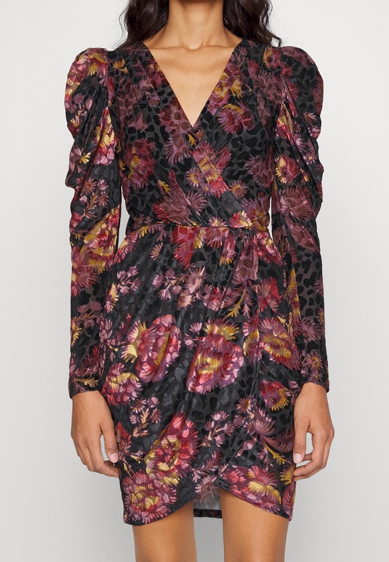 Robe portefeuille fleurie avec manches longues bouffantes, base noire et motifs floraux éclatants en rose, orange et jaune. Tissu texturé avec une taille cintrée.