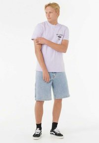 Hellblaues T-Shirt mit einem kleinen Grafik, kombiniert mit Denim-Shorts, schwarzen Socken und schwarz-weißen Sneakers. Lässiger Schnitt und Stil.