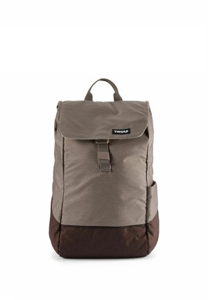 Brown and dark brown Thule backpack with a top flap and front buckle closure, and a fabric handle on top.