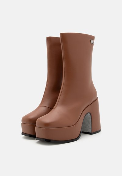 Bottines à plateforme en simili cuir marron avec un large talon bloc, un bout arrondi et un subtil détail en métal argenté près de la cheville.