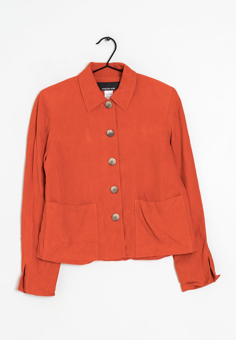 Ruskinkuja takki, jossa on kaulus, kuusi nappia edessä sekä kaksi etupussia. Suuri kangas, rento istuvuus ja pitkät hihat.