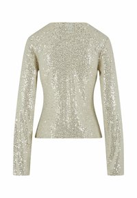 Vue arrière d'une veste beige ajustée à manches longues, entièrement recouverte de sequins argentés scintillants.