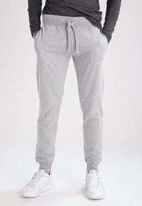 Light gray jogger pants made of soft cotton blend, featuring an elastic waistband with drawstrings and ribbed cuffs.