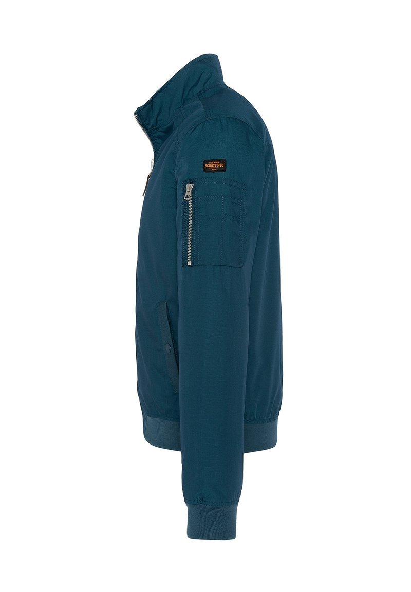 Veste bomber pour homme de couleur teal foncé avec un col haut, des poches latérales et une poche zippée sur la manche gauche. Tissu lisse, poignets côtelés.