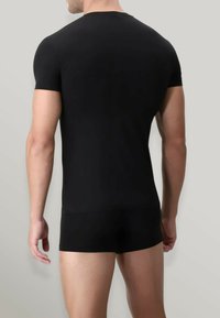 T-shirt aderente nero a maniche corte realizzato in un tessuto liscio e elasticizzato. Design semplice con colletto tondo, che mette in risalto una vista posteriore senza cuciture.
