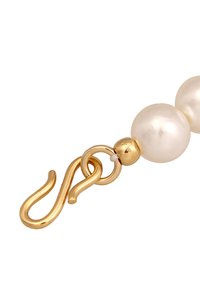 Des perles blanches reliées par une chaîne en or et un fermoir. Le fermoir présente un design torsadé avec une surface lisse et brillante.