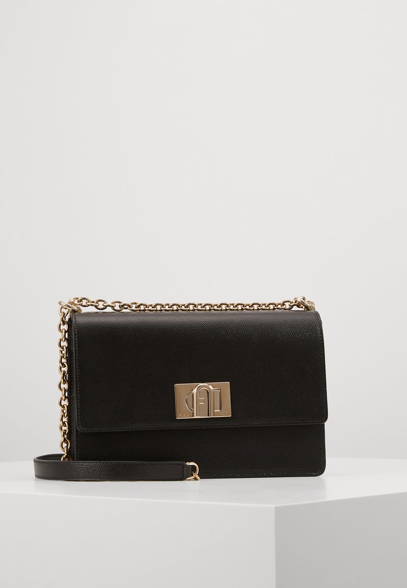 Sort læder crossbody taske med en tekstureret overflade, hardware i guldtoner og en lås. Har en kædetræk og en aftagelig skulderrem.