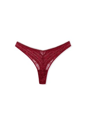 Tanga in pizzo bordeaux con motivi floreali, vita scallop e schiena sottile. Texture delicata e trasparente in tutto il capo.