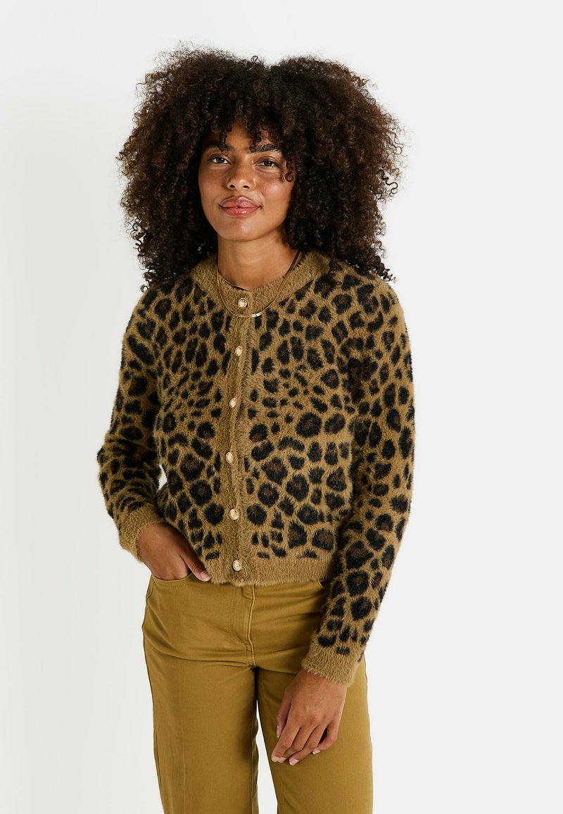 Cardigan confortable à motif léopard en matériau doux marron avec des taches noires, doté d'un col rond, de manches longues et d'une fermeture à boutons.