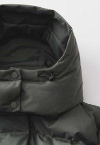 Veste en doudoune verte foncée avec un col haut, présentant un extérieur lisse, une finition mate, deux boutons-pression et un cordon de serrage ajustable.
