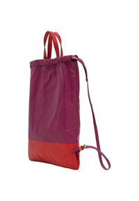 Sac fourre-tout violet et rouge avec une sangle réglable, un haut à cordon de serrage, une texture lisse et une section inférieure contrastante. Matériau durable, design moderne.