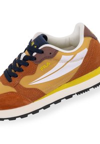 Brune og sennepsfarvede sneakers med ruskind og tekstilmaterialer, hvide accenter, gul mellemsål og marineblå snørebånd. Har en polstret krave.