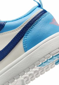 Niebiesko-biały sneaker z teksturowaną skórzaną cholewką, kontrastującymi niebieskimi akcentami, wyściełanym kołnierzem oraz białą gumową podeszwą z wzorzystym bieżnikiem.