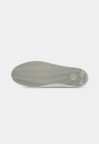 White shoe sole featuring a wavy texture, with "Gabor" branding and a circular tread pattern, primarily in a light grey color.