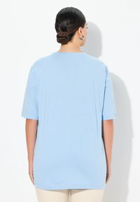 T-shirt azzurro chiaro a maniche corte con scollo rotondo. Tessuto morbido e liscio con una vestibilità ampia. Nessun motivo o accento visibile.