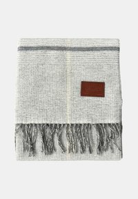 Sciarpa intrecciata grigio chiaro con strisce grigio scuro, estremità frangiate e un'etichetta in pelle marrone su sfondo bianco.