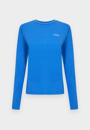 Camiseta de algodón azul de manga larga con cuello redondo y un pequeño logo blanco "OBEY" en el pecho. Textura suave, ajuste relajado.