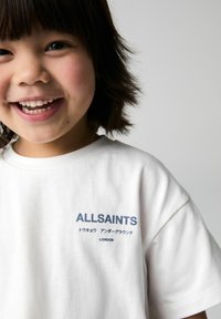Bílý bavlněný tričko s modrým logem "ALLSAINTS" a dalším textem, krátké rukávy a kulatý výstřih.
