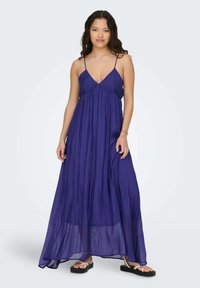 Vestido maxi largo y fluido en tela de color púrpura profundo con escote en V, tirantes ajustables y una textura ligera y aireada.