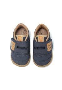 Chaussures pour tout-petits bleu marine en matériau synthétique doux, avec des accents beiges, des sangles velcro et une semelle en caoutchouc avec une texture antidérapante.