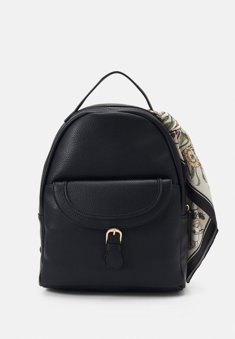 Schwarzer Leder-Rucksack mit runder Form, strukturiertem Finish, Fronttasche und goldfarbener Hardware; mit einem gemusterten Schal-Akzent auf einer Seite.