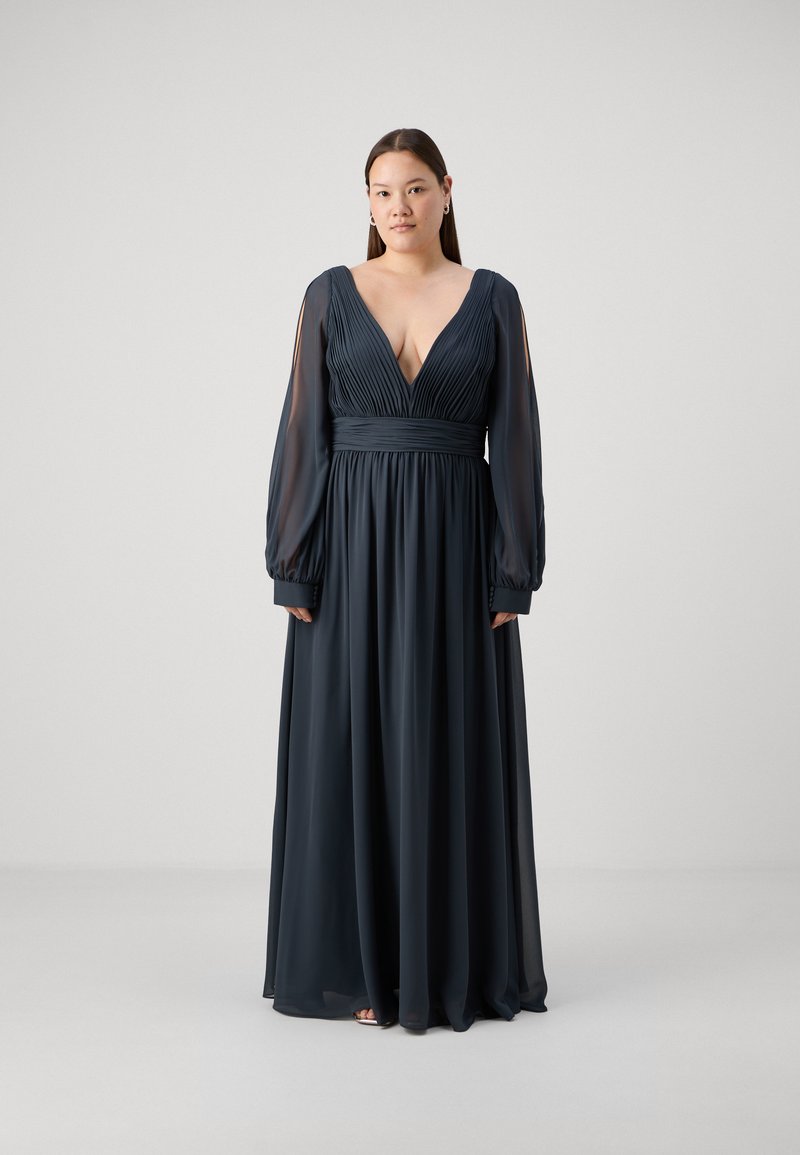 Robe longue bleu marine en tissu fluide, dotée d'un décolleté en V profond, d'un corsage plissé et de manches longues transparentes.