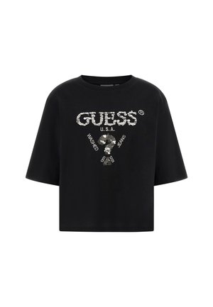 Cropped top nero a maniche corte con testo in paillettes argento "GUESS U.S.A." e un punto interrogativo, con la scritta "Washed Jeans" stampata intorno.