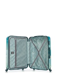 Maleta rígida en color teal con patrones geométricos. El interior cuenta con un forro gris, un bolsillo con cremallera y correas cruzadas para asegurar los objetos.