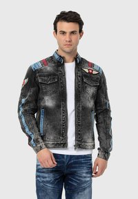 Jeansjack in vervaagde grijs met blauwe accenten. Voorzien van schouderpatches, ritssluiting aan de voorkant, twee borstzakken en een gestructureerd kraagontwerp.