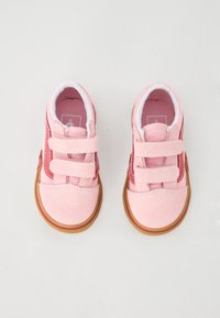 Chaussures roses en daim avec deux bandes Velcro, une semelle en caoutchouc et des accents rouges sur le côté, conçues pour le confort et une utilisation facile.