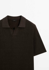 Polo en maille à manches courtes de couleur brun foncé avec un large col plat et une encoche en V au niveau de l'encolure.