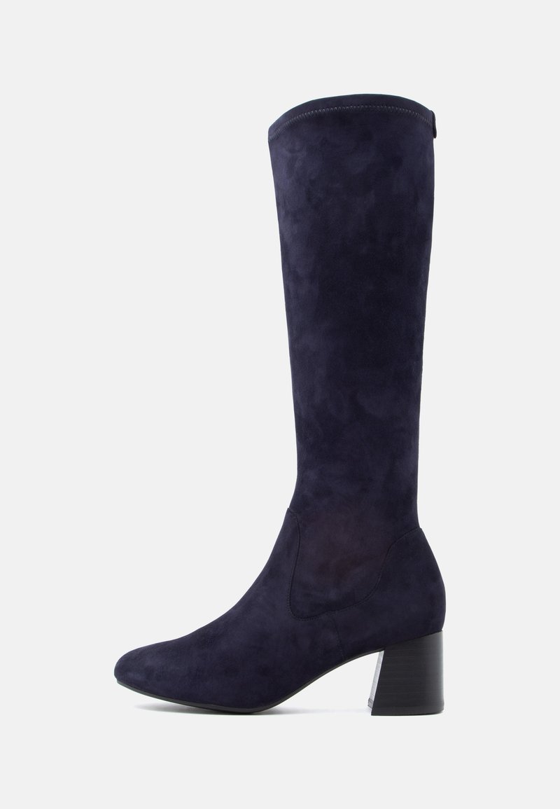 Térdmagasságú csizma sötét navy velúrból, hegyes orral és tömbsarkal. Simaság jellemzi, minimális varrási részletekkel.