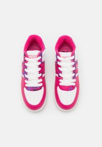 Růžové a bílé tenisky s hladkým koženým svrškem, které mají vzorovanou boční část, bílé tkaničky a měkké růžové vnitřní podšívku.