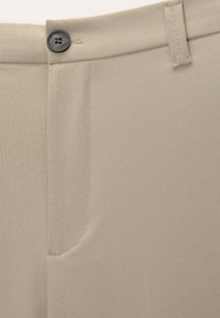 Pantaloni beige in tessuto liscio e strutturato. Presentano una chiusura con bottone e una tasca frontale. Vestibilità su misura con design a gamba dritta.