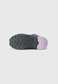 Semelle de chaussure de trail en matériau en caoutchouc durable, surface noire texturée avec des accents roses prononcés et crampons de traction multidirectionnels.