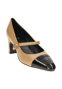 Zapato de tacón de cuero beige con punta en charol negro y correa ajustable con herrajes dorados, montado sobre un tacón cuadrado.