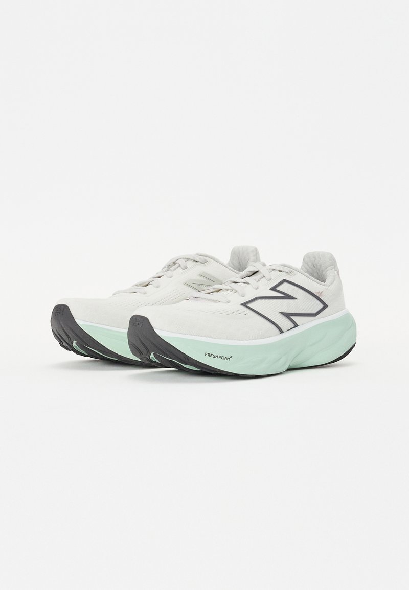 Zapatillas de running de color gris claro con acentos en negro y verde menta, parte superior de malla, suela acolchada y suela texturizada para agarre.